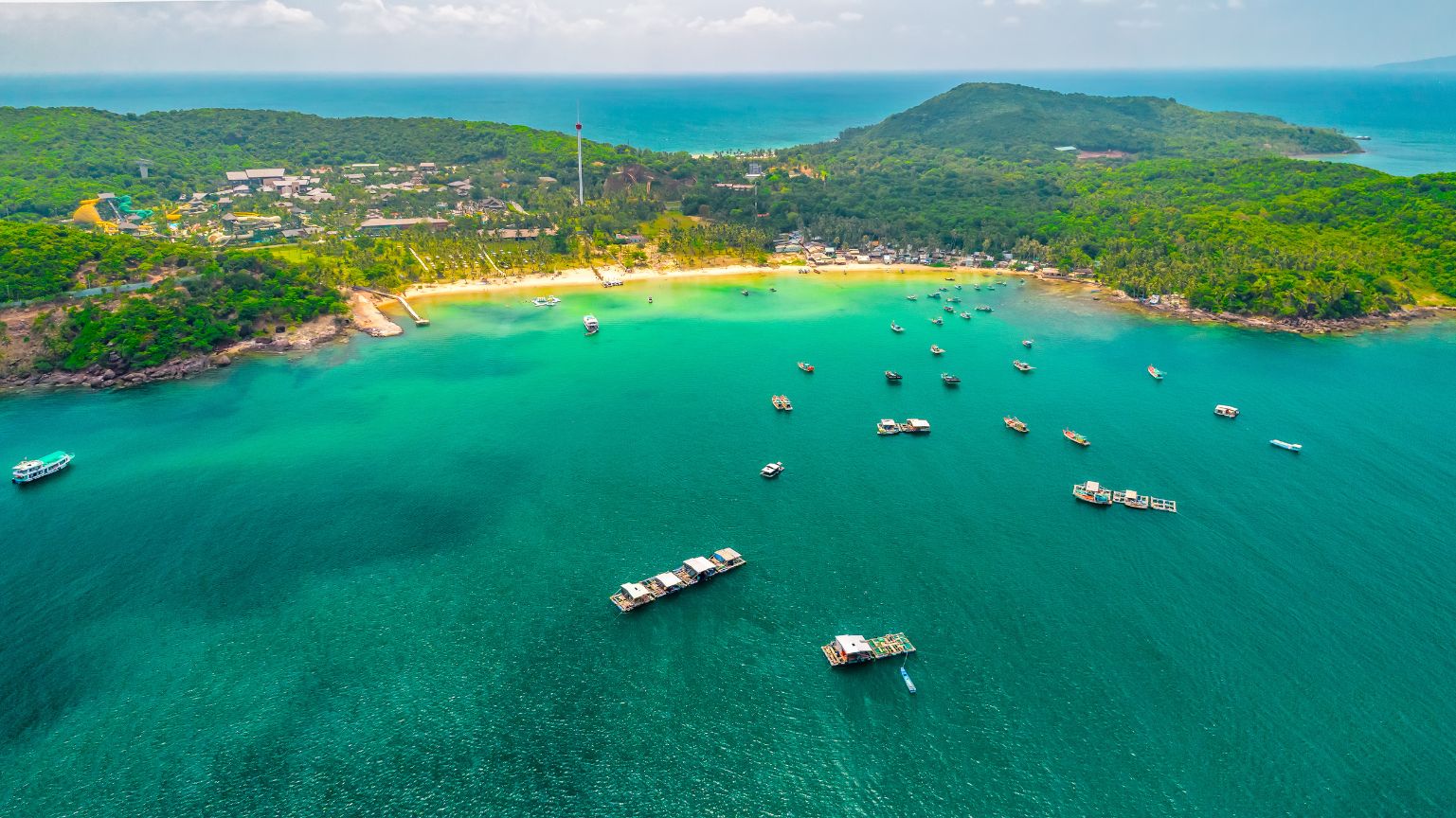 Boats on clear sea at Bai Sao Beach with green hills in Phu Quoc