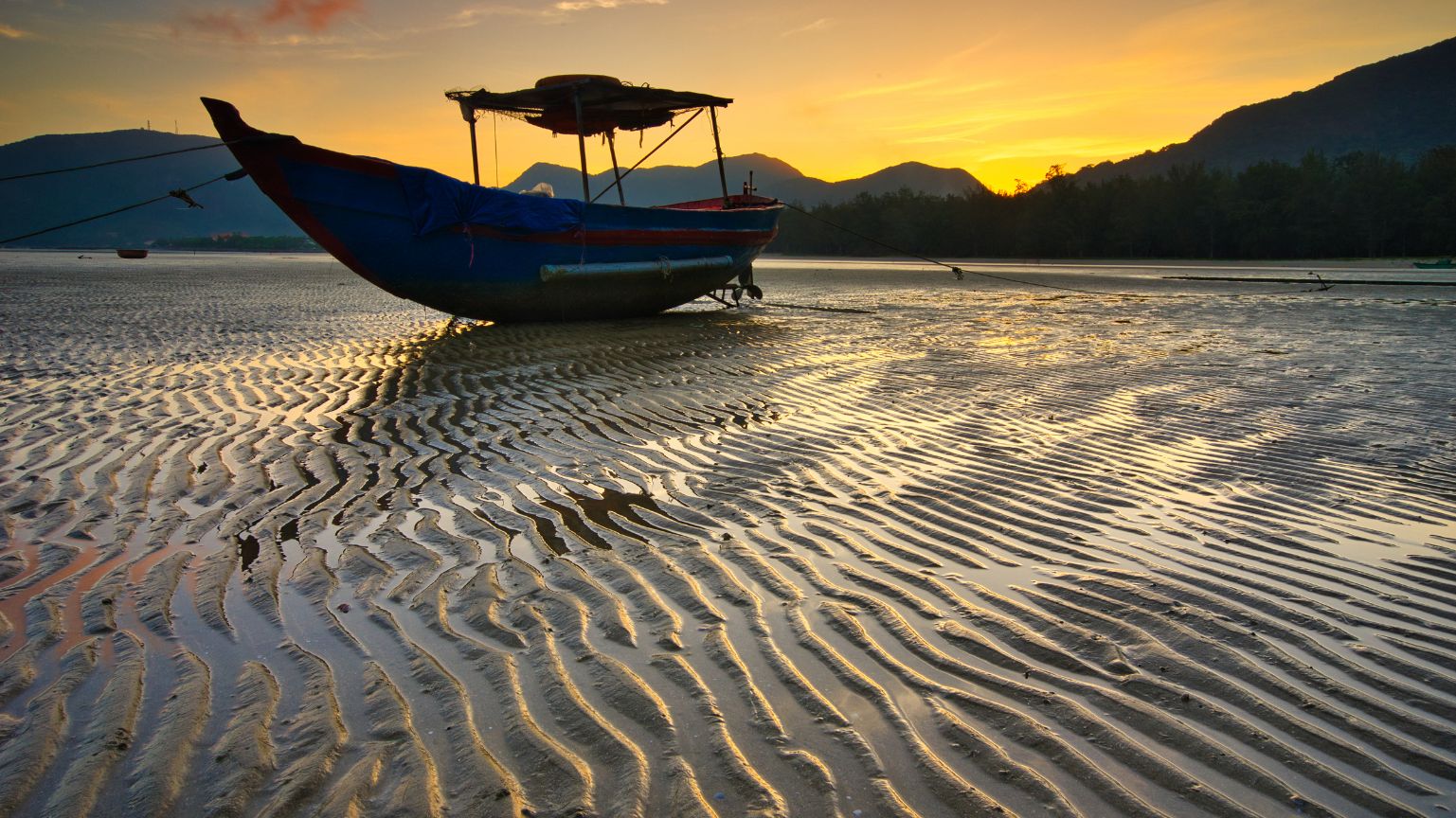 Sunset over tidal sand patterns at Con Dao Beaches with calm coastal view