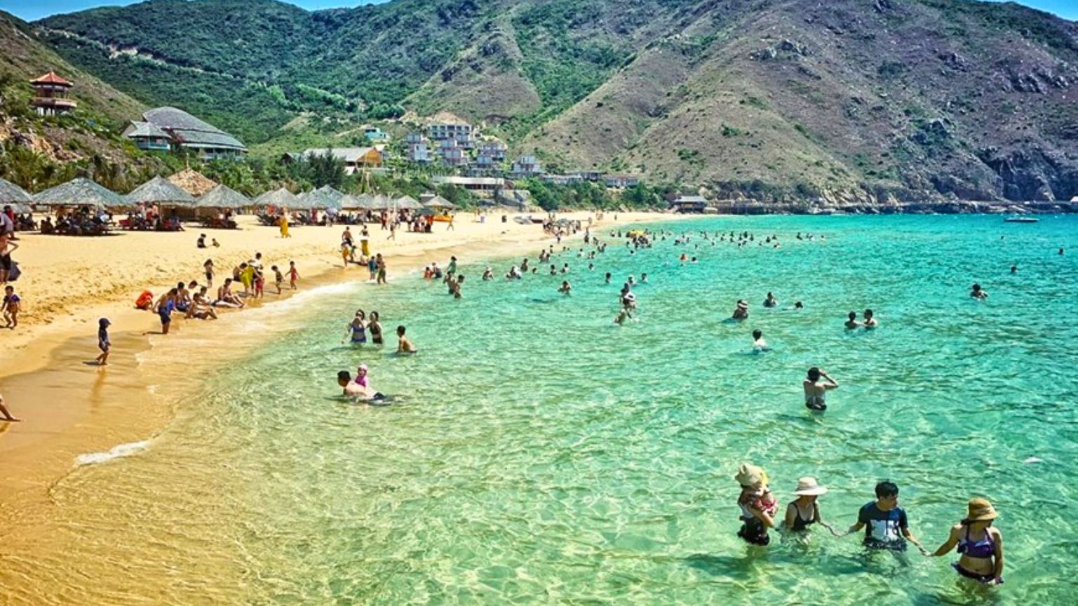 Ky Co Beach Quy Nhon with clear water and swimmers on sandy shore.