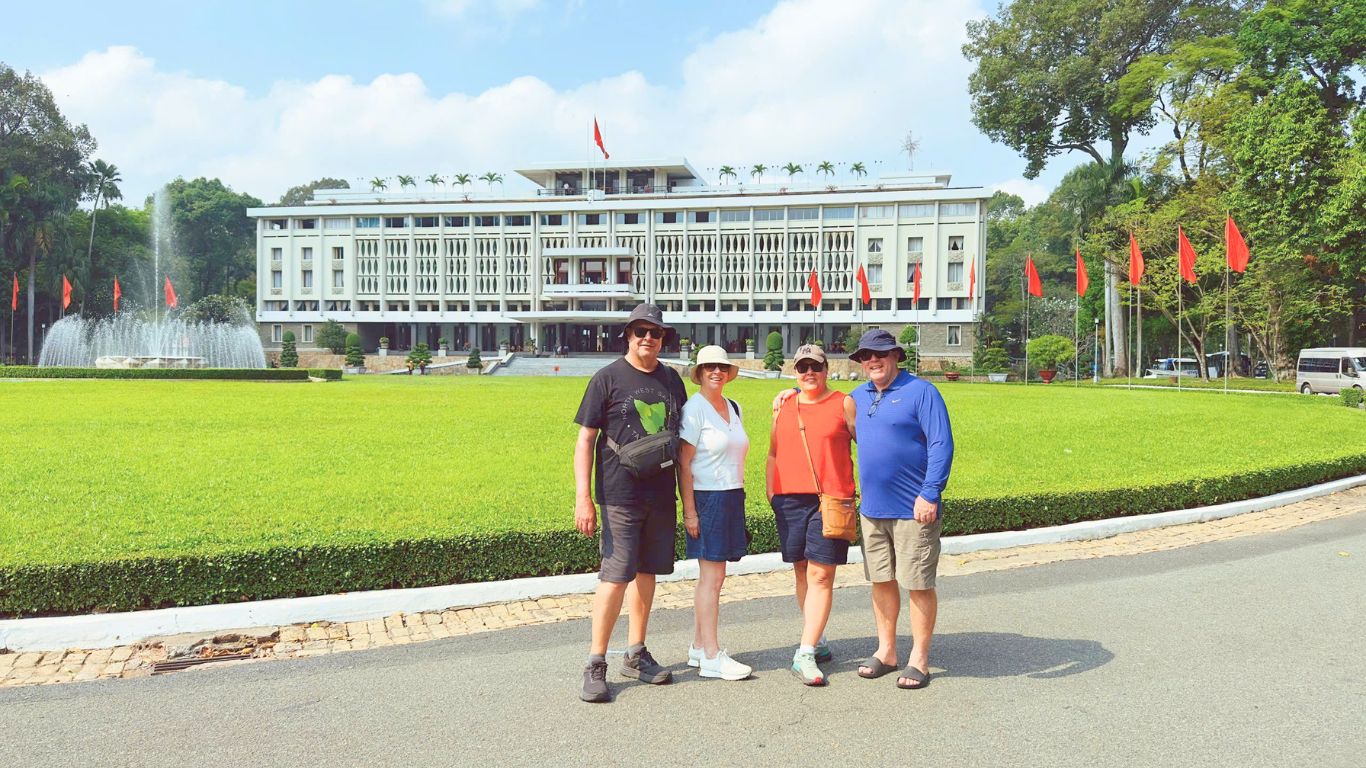 Tourists posing in front of Independence Palace in Ho Chi Minh City on a sunny June morning