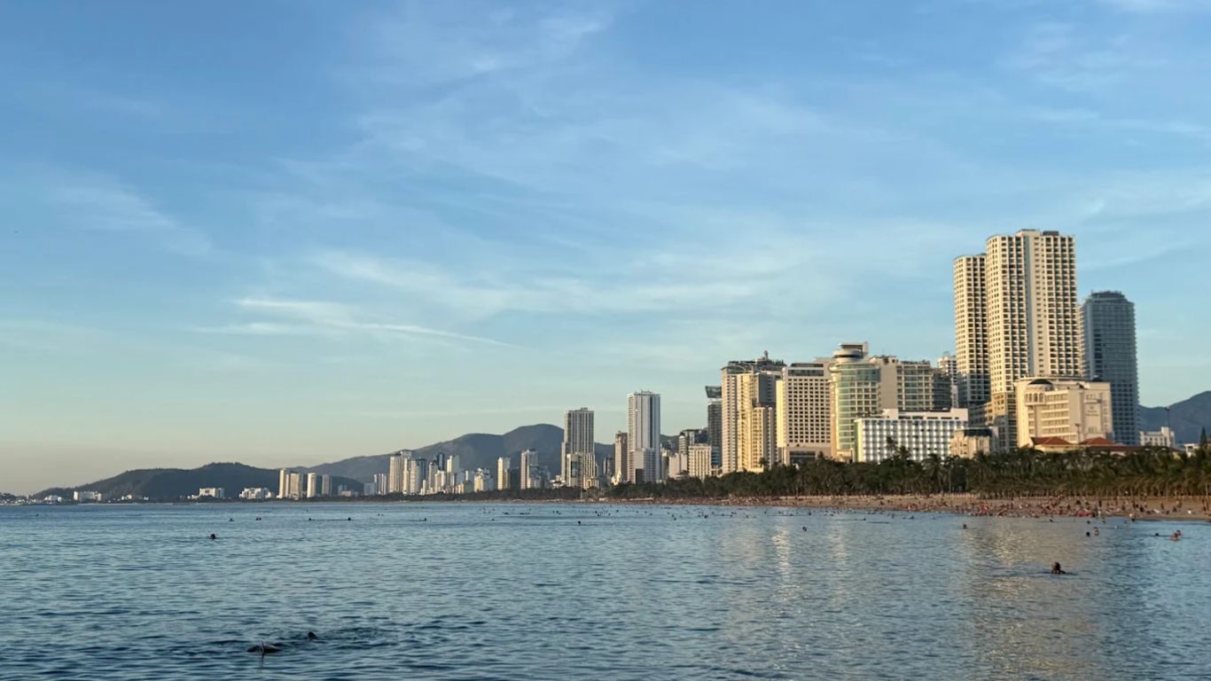 Tran Phu Beach Nha Trang in June with swimmers and beachfront hotels along the coastline