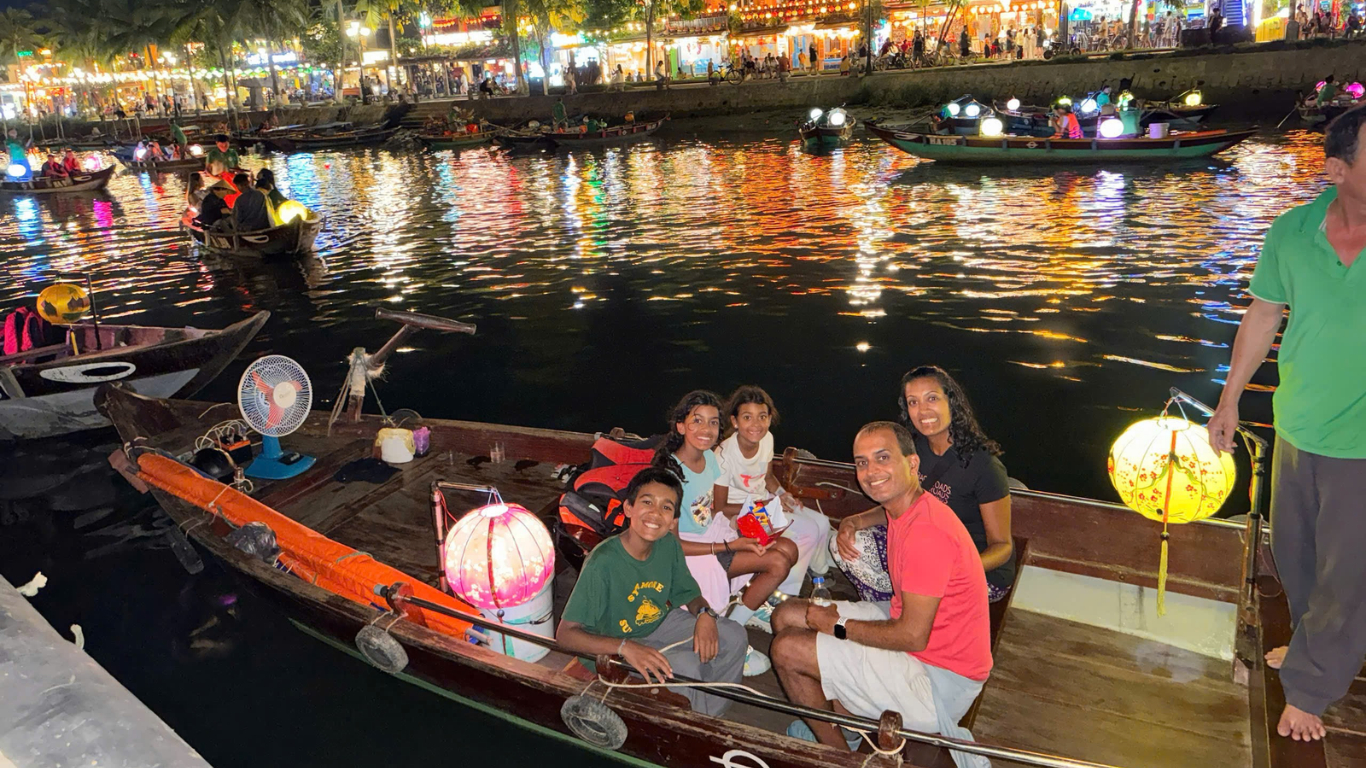 Family on lantern boat trip on Thu Bon River in Hoi An at night