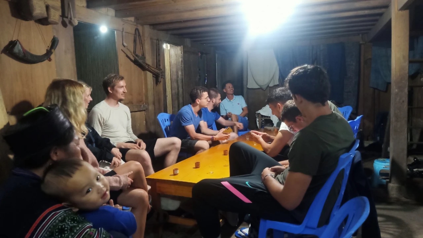 Travelers sharing a village homestay evening with local family in Sapa