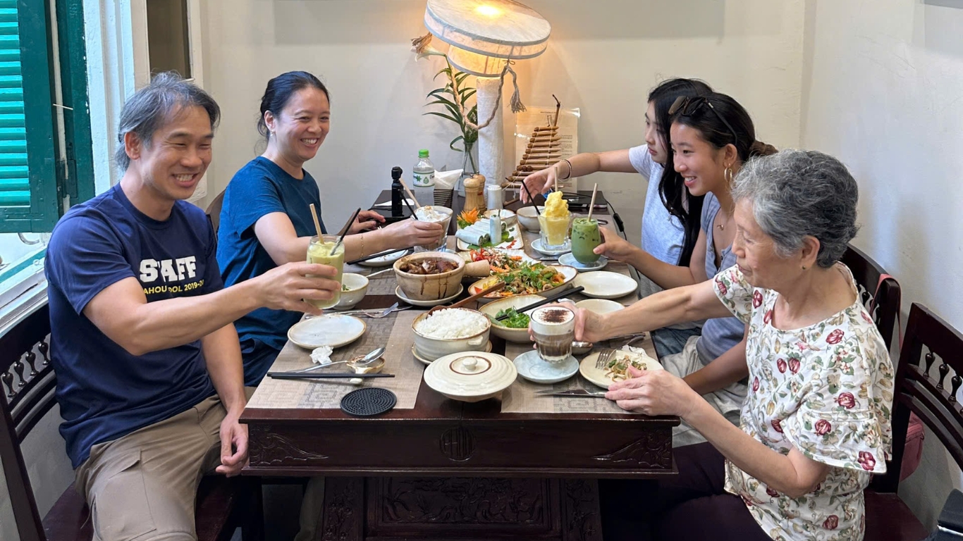 Family sharing traditional Vietnamese meal at Hanoi restaurant table, Hanoi food and dining experience